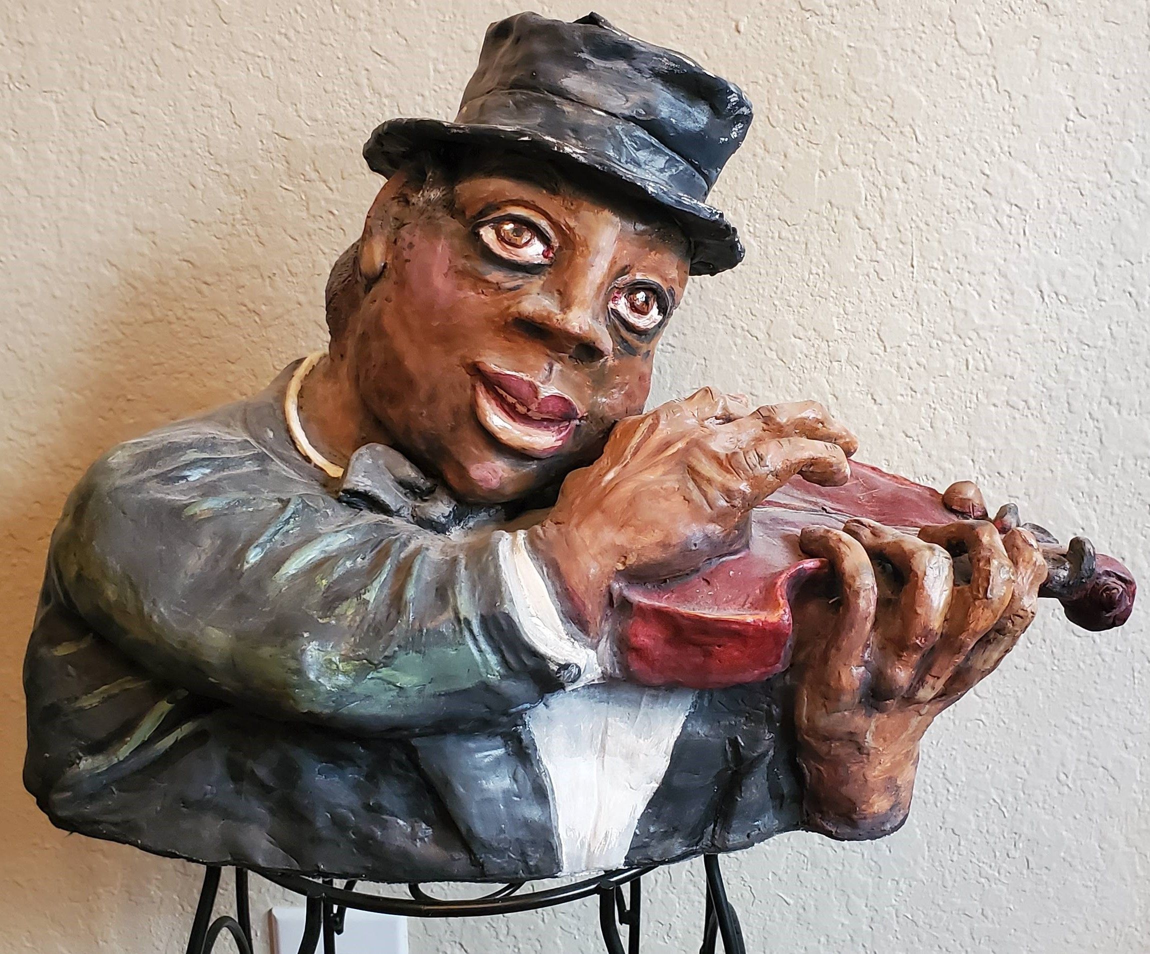 A sculpture of a well-dressed violinist playing his instrument